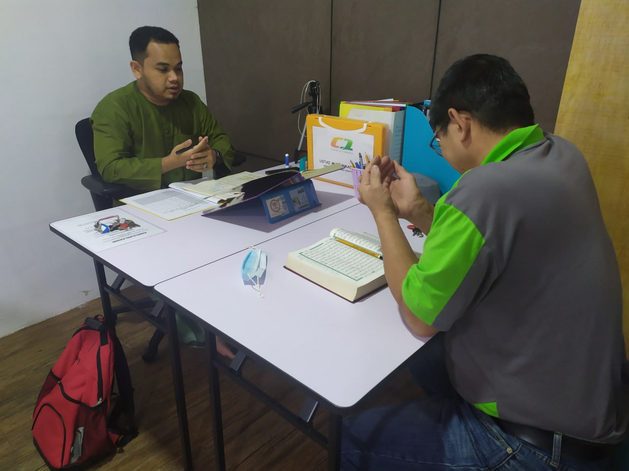 Ustaz membimbing pelajar membaca Al-Quran