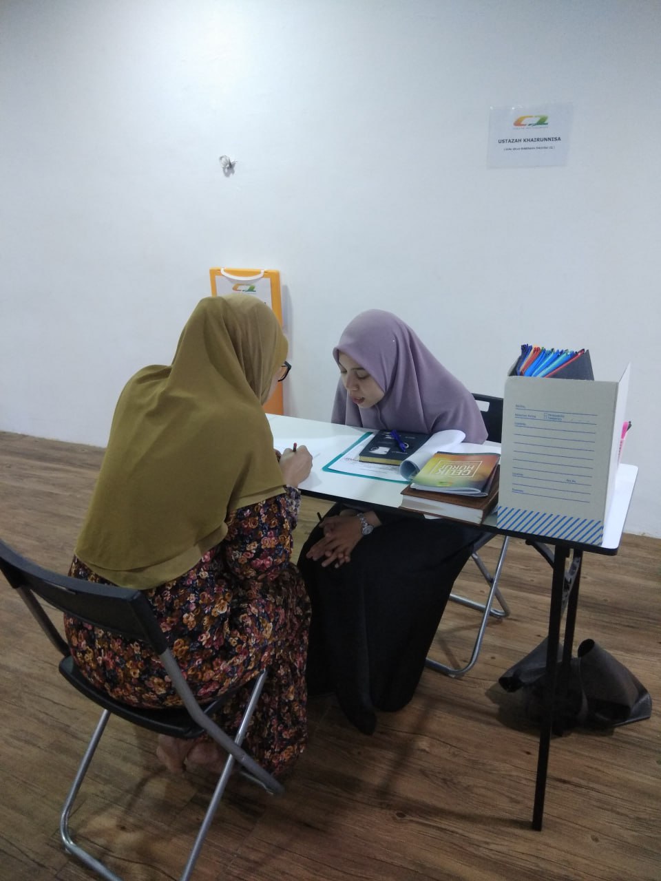 Ustazah membimbing pelajar dewasa dengan sabar